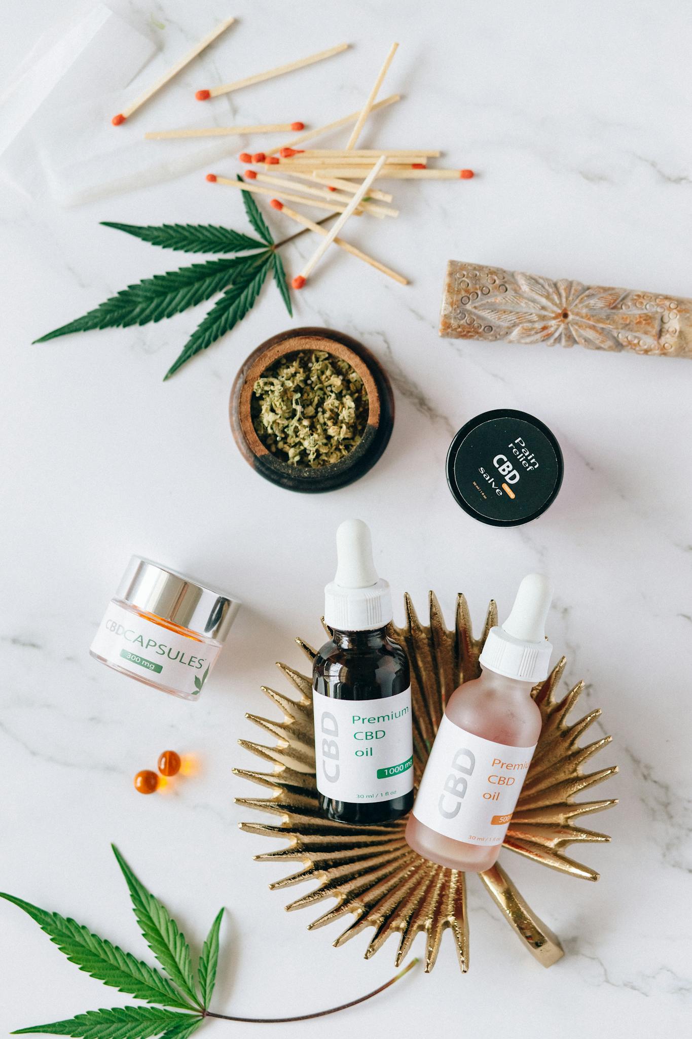 Flat lay of premium CBD oil, capsules, and cannabis leaves for wellness and relaxation.